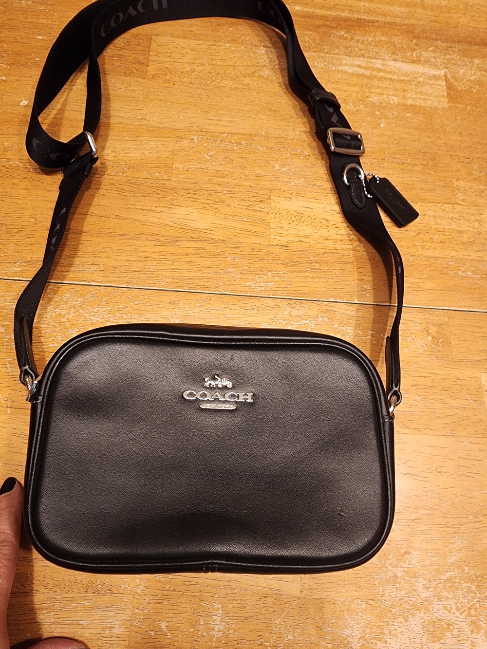 black leather Coach Mini Jamie Camera Bag features a silver-toned metal logo